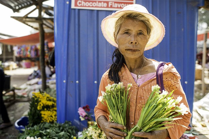Фотография женщины-продавца на рынке, продающей цветы, как создать белый фон фотографии