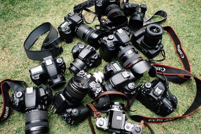 Overhead shot of DSLR cameras on grass- sell camera gear