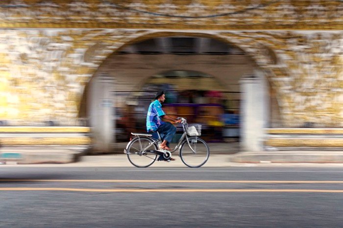 Мужчина едет на велосипеде через туннель