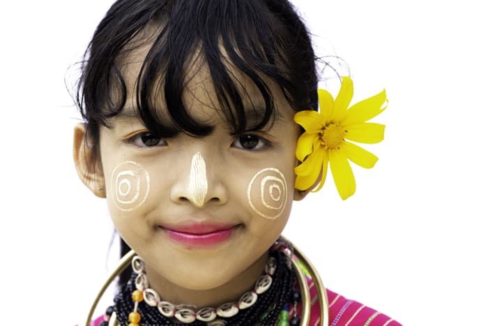 Close up portrait of the young girl in traditional face paint against the white portrait photo background