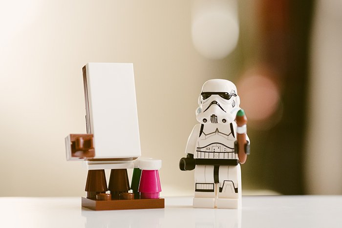 Cool close up toy photography of lego storm trooper painting on the toy easel