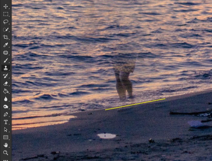 Скриншот, показывающий, как удалить что-то в фотошопе, используя фотографию женщины, идущей по пляжу в вечернее время