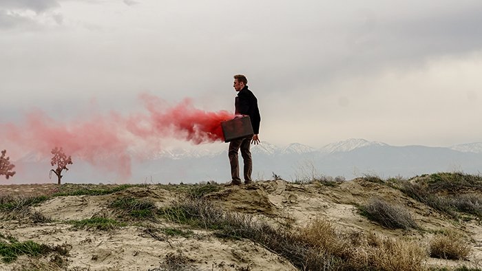 Атмосферный портрет женщины, держащей красные дымовые гранаты