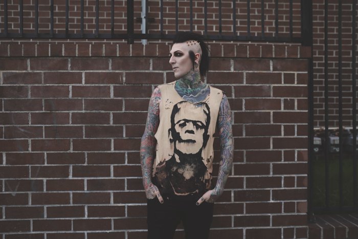 Татуированная мужская модель позирует на открытом воздухе - тату-фотография