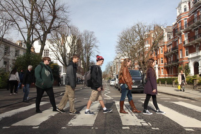 Группа из 5 человек пересекает улицу на Эбби-роуд в стиле Битлз