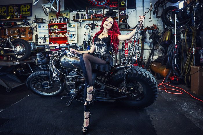 Крутой мотоциклетный фотопортрет женской модели, позирующей на мотоцикле