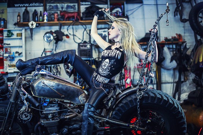 Крутой мотоциклетный фотопортрет женской модели, позирующей на мотоцикле