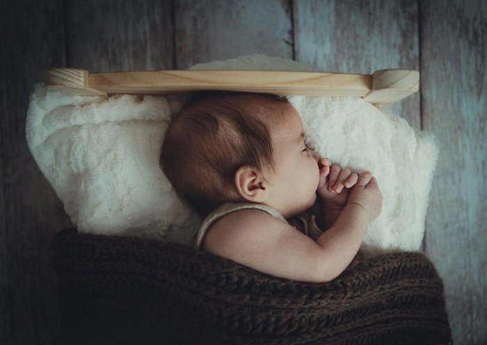 Портрет новорожденного в маленькой кроватке