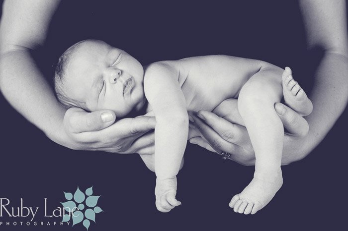 Черно-белый портрет новорожденного в руках родителей