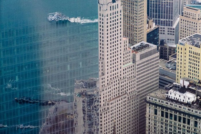 Воздушный городской пейзаж со зданиями и морем, отраженными в стеклянных окнах соседнего здания - советы по съемке отражений