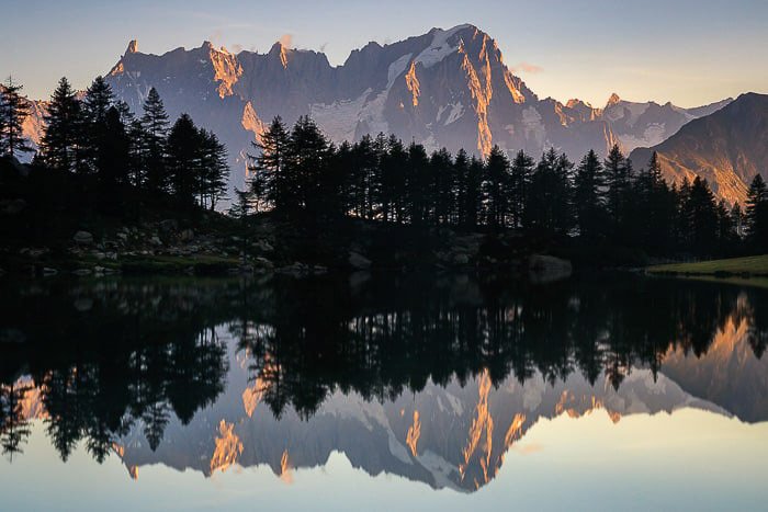Потрясающий горный пейзаж, отражающийся в озере внизу - отражения в фотографии