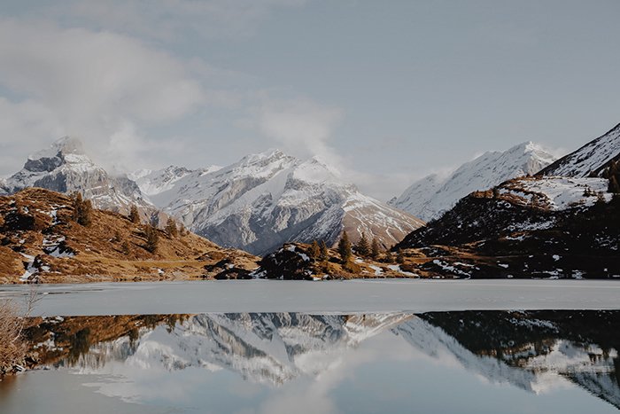 Потрясающий горный пейзаж с озером, добавляющим отражение и глубину - симметрия в фотографии