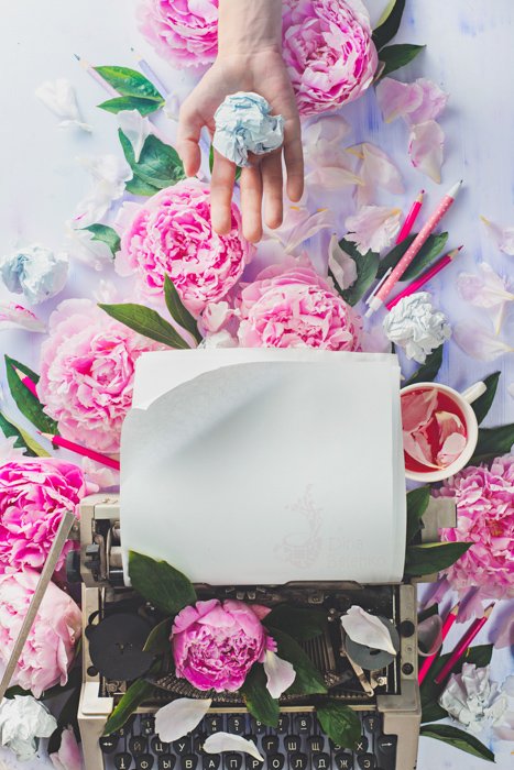 Яркая и воздушная композиция из розовых роз вокруг печатной машинки