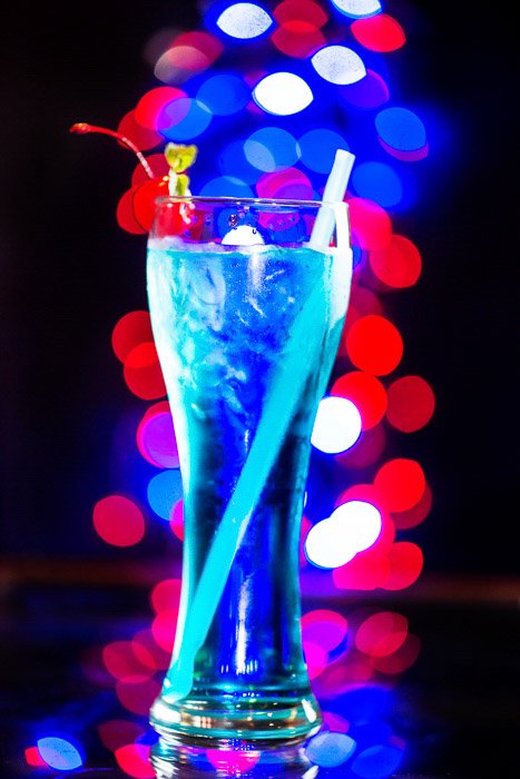 Голубой коктейль с размытым боке на светлом фоне