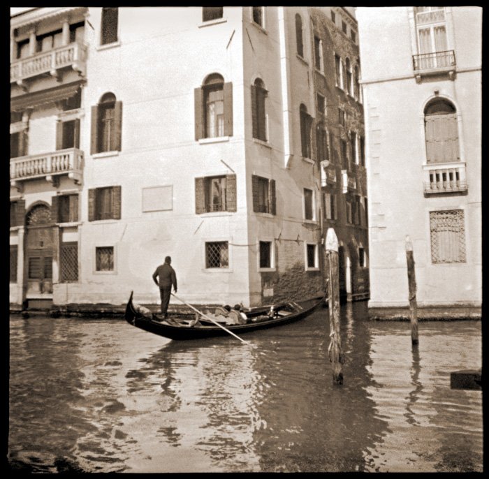 Черно-белая фотография мужчины в гондоле в Венеции