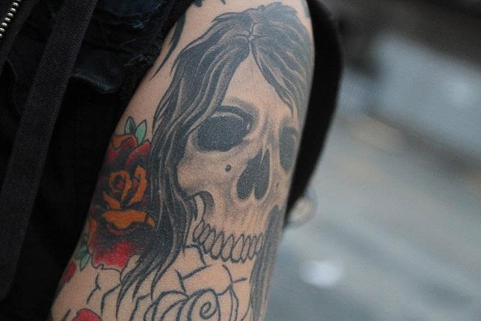 Фотография татуировки черепа на верхней руке человека крупным планом