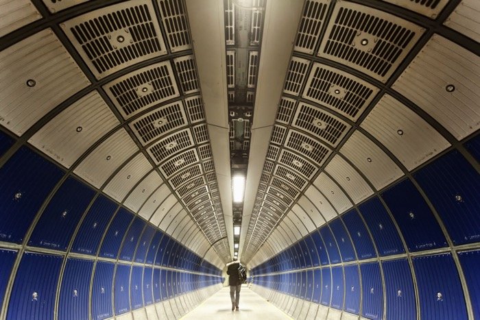 Человек идет по тоннелю на юбилейной линии лондонского метро