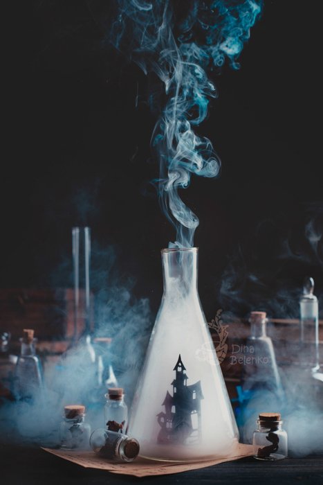 Атмосферная магическая тематическая композиция натюрморта с участием стеклянных бутылок, дыма и пробирок