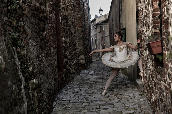 Красивый балетный снимок танцовщицы, позирующей на открытом воздухе