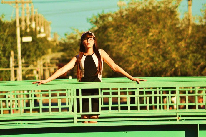 Портрет женщины-модели, позирующей на зеленом мосту, с длинными ракурсами камеры