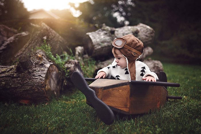 Концептуальная фотография мальчика в деревянной лодке на открытом воздухе
