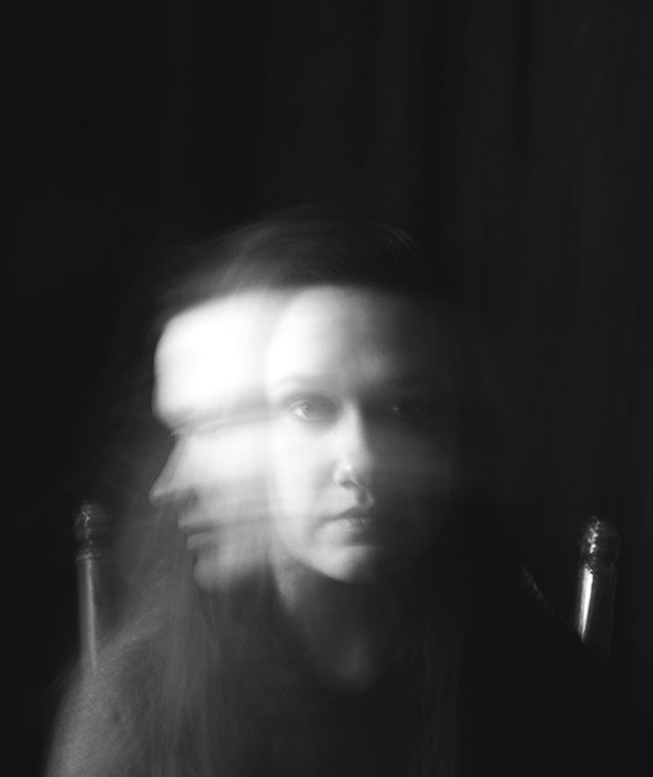 A surreal monotone portrait of a female model featuring motion blur - conceptual photography ideas