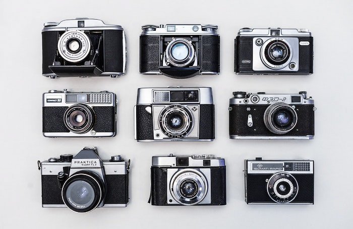 Плоское расположение девяти старых пленочных камер на белом фоне - профессиональная фотосессия