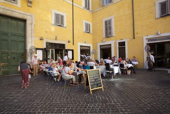 A crowded outdoor restaurant in rome - best rome photography spots