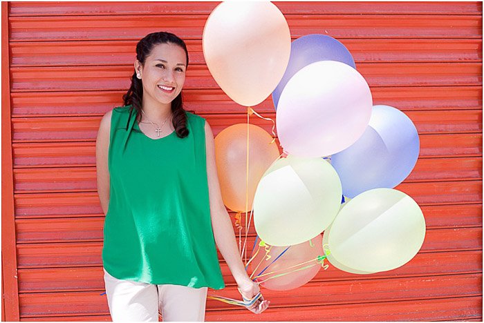 Женщина-модель позирует с воздушными шарами перед красной дверью - как фотографировать людей