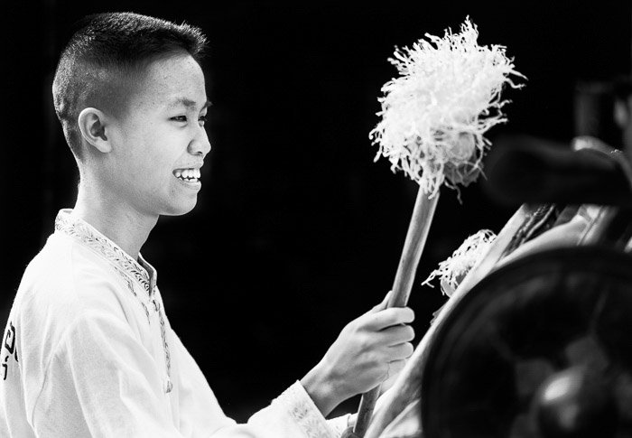 Однотонный портрет тайского мальчика-барабанщика на фестивале - идеи нарративной фотографии