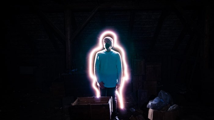 Креативный портрет человека с окружающей его линией светового рисунка, снятый с использованием светодиодных инструментов для рисования светом