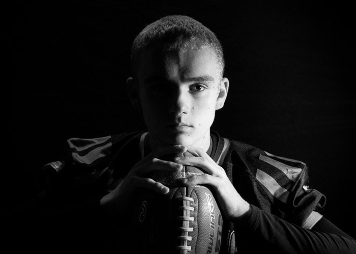 Атмосферный черно-белый портрет молодого парня, снятый с использованием фотографии при жестком свете