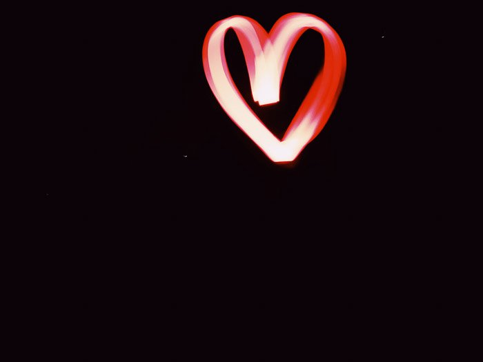 Красная световая картина в форме сердца, снятая ночью с использованием светодиодных инструментов для рисования светом