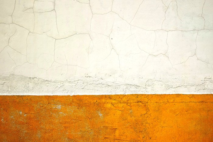 Простой и эффективный пример абстрактной фотографии потрескавшейся бело-желтой стены