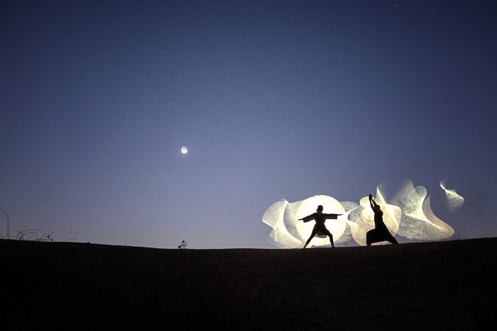 Силуэты двух людей, творчески рисующих светом - фотографии с длинной выдержкой