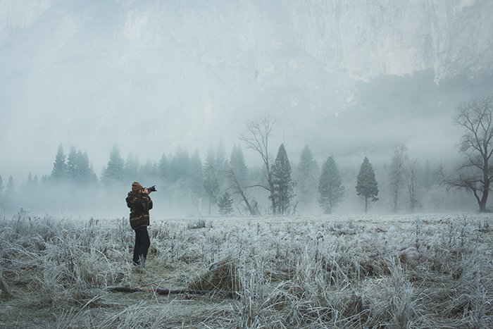 Фотограф снимает в волшебном зимнем пейзаже