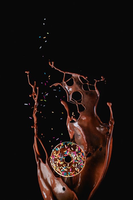 Creative food photography of doughnut in front of the chocolate splash