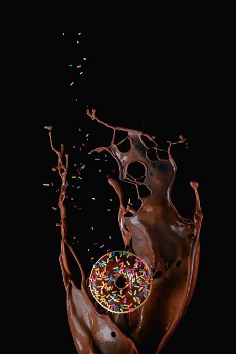 Шоколадный пончик на переднем плане вкусного шоколадного всплеска