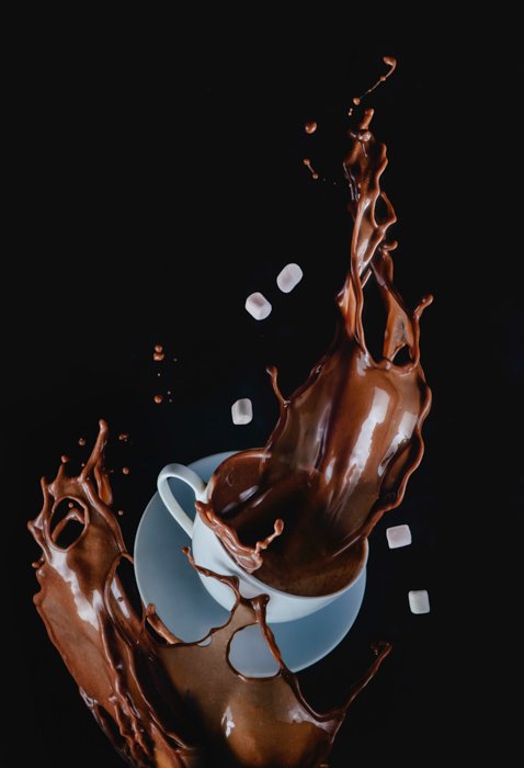 Креативный снимок падающей чашки кофе в середине брызг