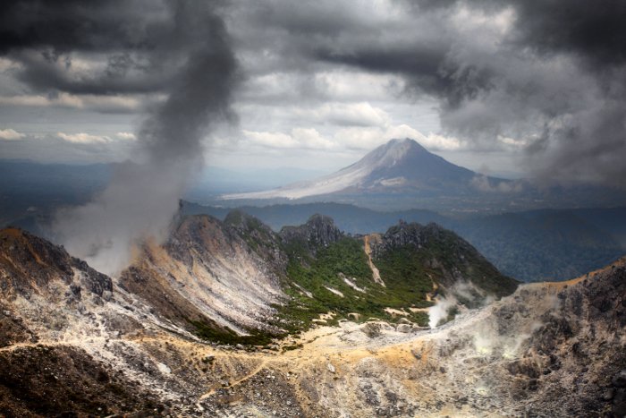 Два вулкана, снятые с горы Сибаяк, и вид в сторону горы Синабунг. Синабунг был активен в то время, когда была сделана эта фотография. Вы можете видеть пепел на левом фланге вулкана.