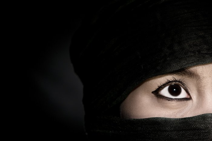 Загадочный портрет крупным планом женской модели в черном головном платке на черном фоне - ошибки освещения фотографии