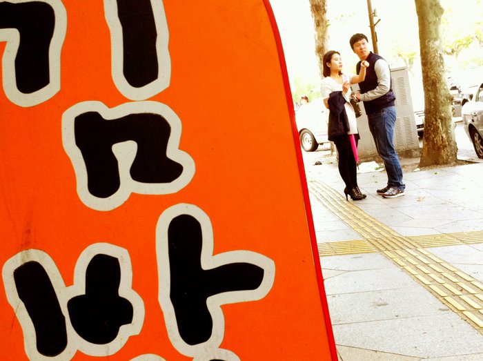 Уличная фотография в Южной Корее с изображением знака и пары
