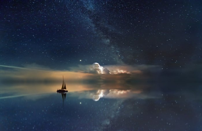 Отредактированное изображение парусника, плывущего в море со звездным небом