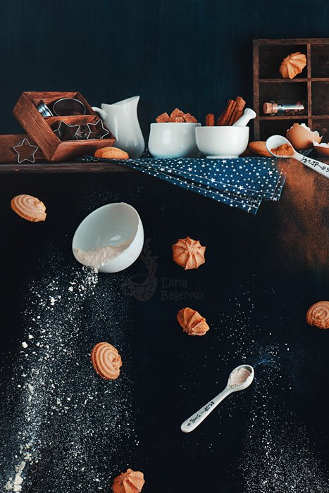 Креативный пищевой натюрморт, включающий кофейные чашки, формочки для печенья, сахар и печенье