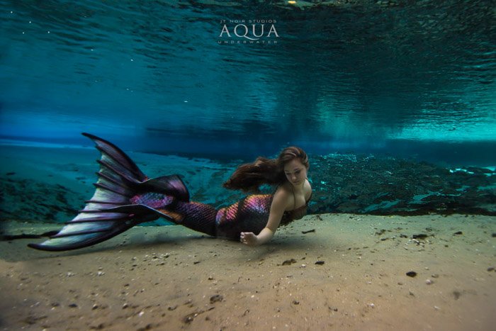 Волшебная подводная фотосессия русалки, в которой модель с хвостом русалки плавает под водой