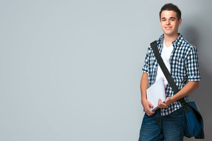 Школьный портрет улыбающегося подростка со школьным портфелем на фоне стены - советы по созданию качественных школьных портретов