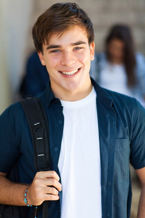 Школьный портрет счастливого мужчины-старшеклассника, улыбающегося в школьном коридоре - советы по созданию качественных школьных портретов