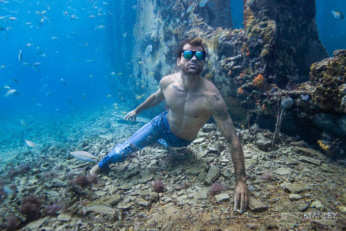 Атмосферная подводная океанская фотография мужской модели, плавающей под водой