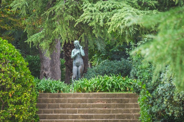 Бронзовая статуя женщины в саду