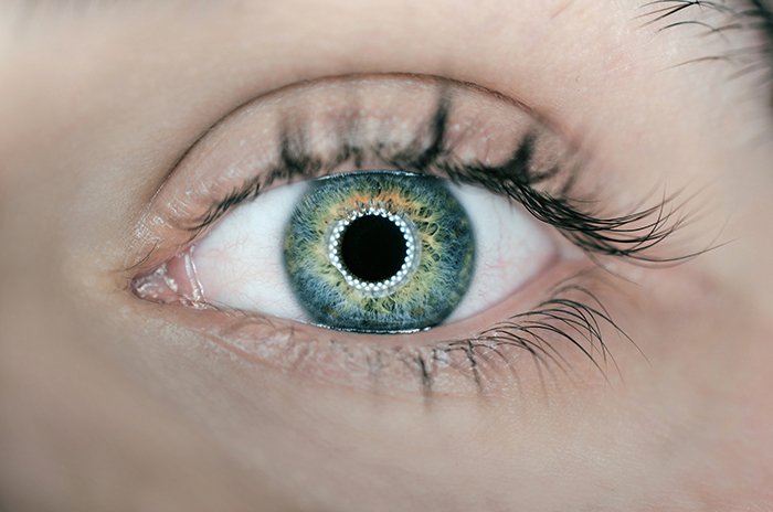 Потрясающий крупный план зеленого глаза человека, снятый с помощью кольцевого света